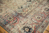 Detailed corner of a distressed Veramin carpet with red and navy Herati border motifs.