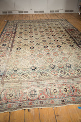 Angled perspective on a distressed Veramin carpet's faded floral field and prominent Herati border.