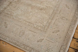 Distressed vintage Sivas rug corner, showing worn floral motifs and muted ivory tones.