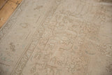 Distressed vintage Sivas carpet with faded neutral floral motifs and visible wear to foundation.