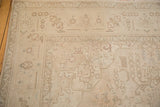 Distressed Sivas carpet corner, featuring faded ivory and pale coffee brown geometric patterns.