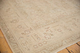 Vintage distressed Sivas carpet corner, muted beige floral design, low pile.