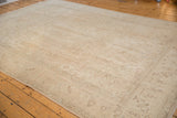 Faded floral motifs and distressed texture in antique ivory and beige tones.
