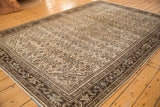 Distressed Malayer carpet featuring aged ivory Herati motif, rich brown border, and subtle aqua tones.
