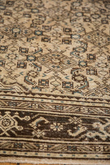 Distressed vintage Malayer carpet, Herati motif, neutral tones, even wear, faint foundation visible.
