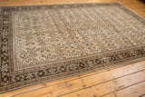 Distressed vintage Malayer carpet corner: worn beige field meets ornate chocolate brown borders.