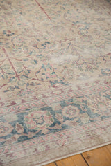 Distressed vintage Turkish Sparta carpet, showing faded palmette border with dusty blue and blush motifs.