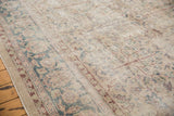 Distressed vintage Sparta carpet showcasing faded ivory, dusty blue, and blush palmette motifs.