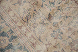 Distressed vintage Sparta carpet with exposed foundation, even wear, and faded floral motifs.