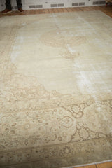 Distressed vintage Tabriz carpet's ivory field reveals pale coffee brown scrolling vinery.