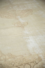 Ivory and pale coffee brown scrolling vinery on a distressed vintage Tabriz carpet.