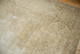Distressed texture on a vintage Tabriz border with scrolling vinery in soft ivory and brown.
