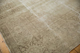 Distressed vintage Tabriz carpet corner showing faded ivory and pale coffee brown vinery.