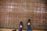 Distressed blush and pale red vintage Malayer rug with faded allover boteh pattern.