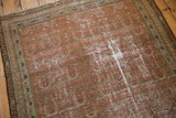 Distressed corner of a vintage Malayer rug, showing blush and beige allover pattern.