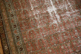 Vintage distressed Malayer rug pile, revealing exposed foundation and muted blush pattern.