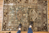 Distressed vintage Malayer rug showing faded blue field, beige animal and plant motifs, and worn pile.