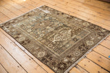 Distressed vintage Malayer rug with playful woven animals, birds, and plant motifs in beige and coffee brown.