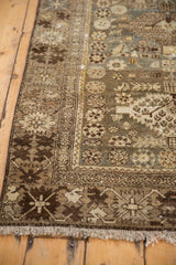 Faded beige and brown border motifs with secure fringe on this vintage Malayer rug.
