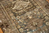 Distressed texture of vintage Malayer rug, showing faded blue, brown, and detailed floral-geometric motifs.