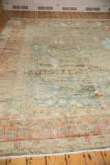 Distressed Lilihan carpet corner, featuring worn blossomed plant border and low pile.