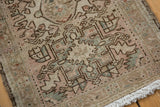 Distressed Karaja rug mat showcasing serrated geometric motifs, soft beige and pink tones, and ivory fringe.