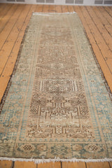 Distressed vintage Karaja runner corner, showing geometric pawn motif and sea foam green plant border.