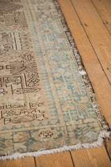 Distressed Karaja runner corner: faded beige, dusty teal geometric pawn motifs, secured fringe.