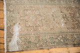 Distressed vintage Karaja rug with large exposed foundation, beige, brown, and teal geometric pattern.