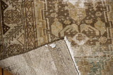 Folded vintage distressed Hamadan runner, revealing worn pile, foundation, and fringe.