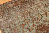 Distressed Qashqai rug close-up: worn pile, visible foundation, and muted rust, blue, ivory.