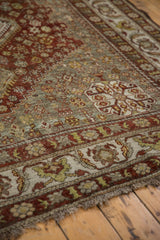 Distressed vintage Shiraz carpet with muted dark copper floral border and faded ocean green field.