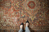 Distressed vintage Heriz carpet: geometric vinery, palmettes, and textured terracotta, slate blue.