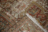 Worn pile texture of a distressed vintage Heriz rug, with terra cotta, blue tones, and fringe.