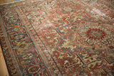 Distressed vintage Heriz rug showing geometric field, soft terra cotta, and slate blue hues.