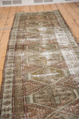 Distressed vintage Caucasian runner's geometric diamond motifs, with worn pile in dusty red and moss green.