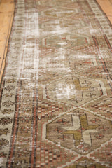 Distressed Caucasian runner, worn geometric pattern, dusty red, moss green, exposed foundation.