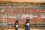 Antique Northwest Persian runner's brick red field with teal hexagons and extensive localized wear.