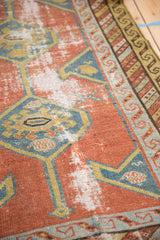 Detailed wear on brick red field and teal hexagonal medallions of an antique Persian runner.