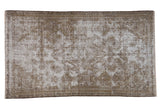 Vintage distressed Malayer rug with faded medallion, decorative worn texture in beige and brown hues.
