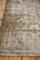 Worn texture and exposed knot heads along the secured side of a distressed Malayer rug.