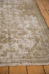 Distressed Malayer rug showing worn beige foundation, exposed knot heads, and dusty gold hues.