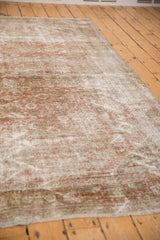 Distressed Mahal carpet texture showing even wear, faded blush and ivory floral motifs.