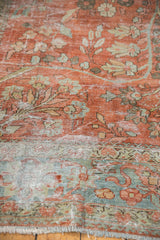 Distressed red floral vinery, ocean green blue border, and fringe on a vintage Mahal carpet.