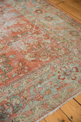Distressed Mahal carpet, showcasing worn floral pattern in soft red, ocean green, and secured fringe.