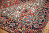 Heriz carpet corner detail with brick red, navy, ivory serrated leaves and patterns.