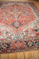 Low pile navy border of the traditional Heriz rug, with brick red floral patterns and fringe.