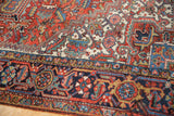 Vintage Heriz rug detail: navy blue border with geometric patterns, serrated leaves, and floral cross sections.
