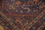 Vintage Shiraz carpet corner with playful serpent motifs, madder red, and geometric borders.