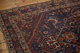 Detailed corner of Vintage Shiraz carpet, rich cobalt blue and madder red geometric motifs.